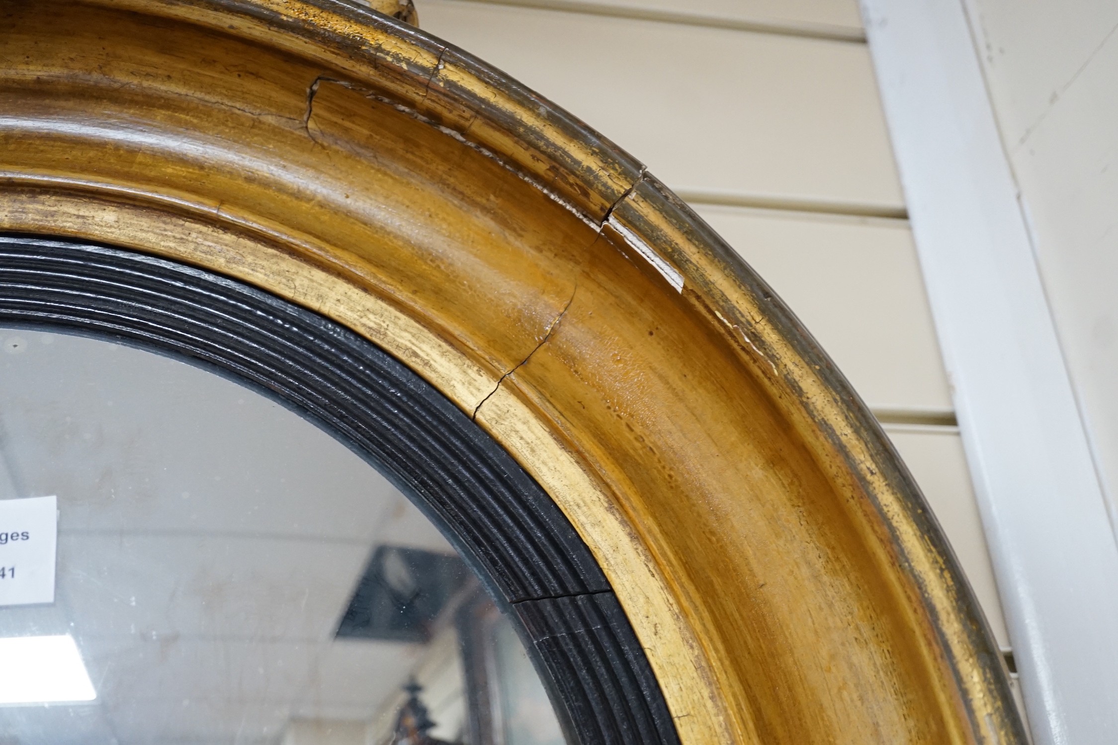 A Regency ebonised and giltwood convex wall mirror, height 87cm *Please note the sale commences at 9am.